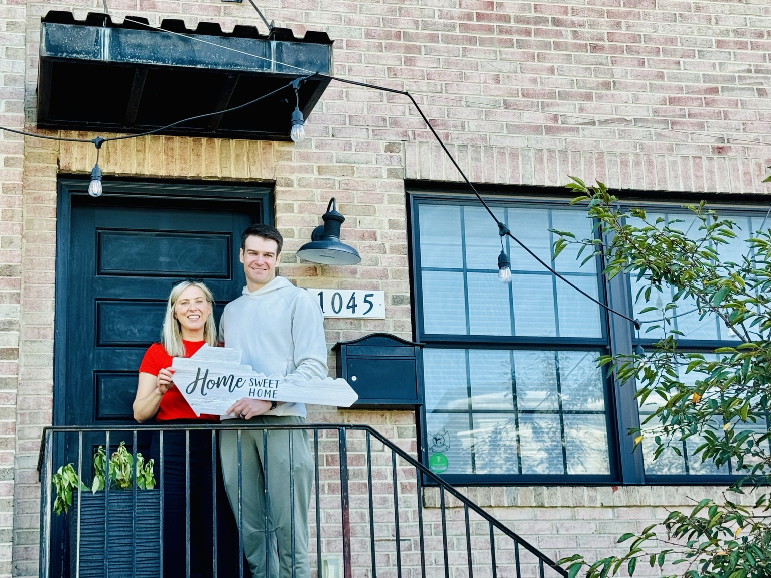Happy Canton homeowners holding a Home Sweet Home sign